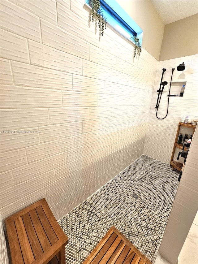 bathroom featuring a shower and tile walls