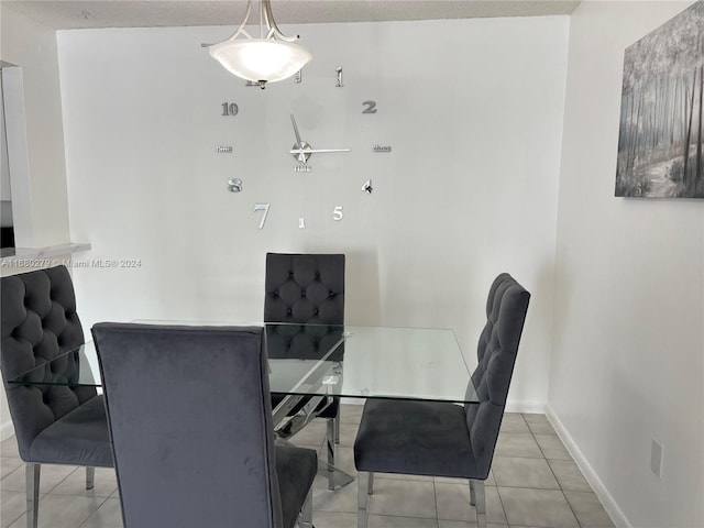 dining room with a textured ceiling and light tile patterned floors