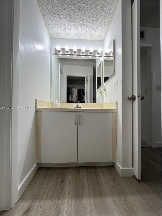 bathroom with hardwood / wood-style floors and a textured ceiling