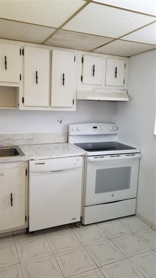 kitchen featuring a drop ceiling, white cabinets, sink, and white appliances