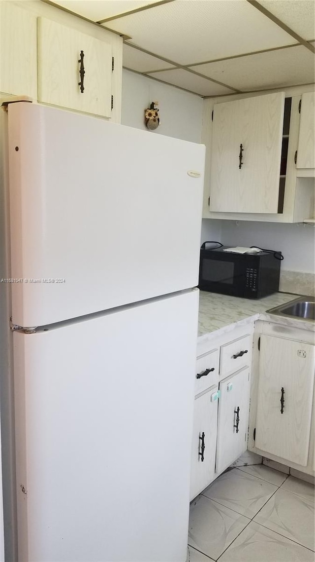 kitchen with sink, white fridge, and a paneled ceiling