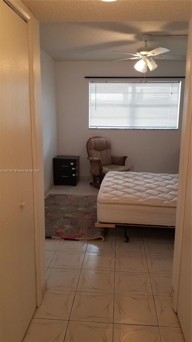 bedroom with a textured ceiling and ceiling fan