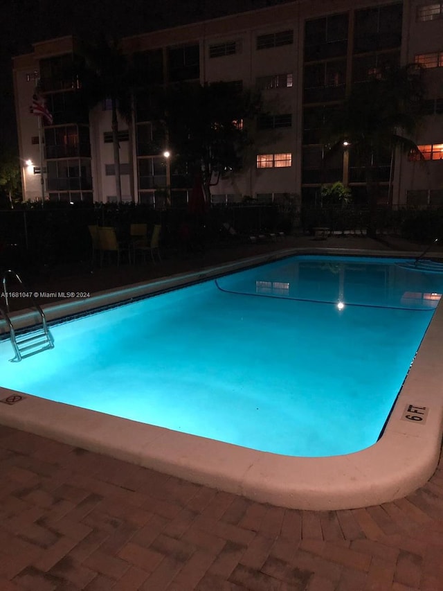 view of pool at twilight