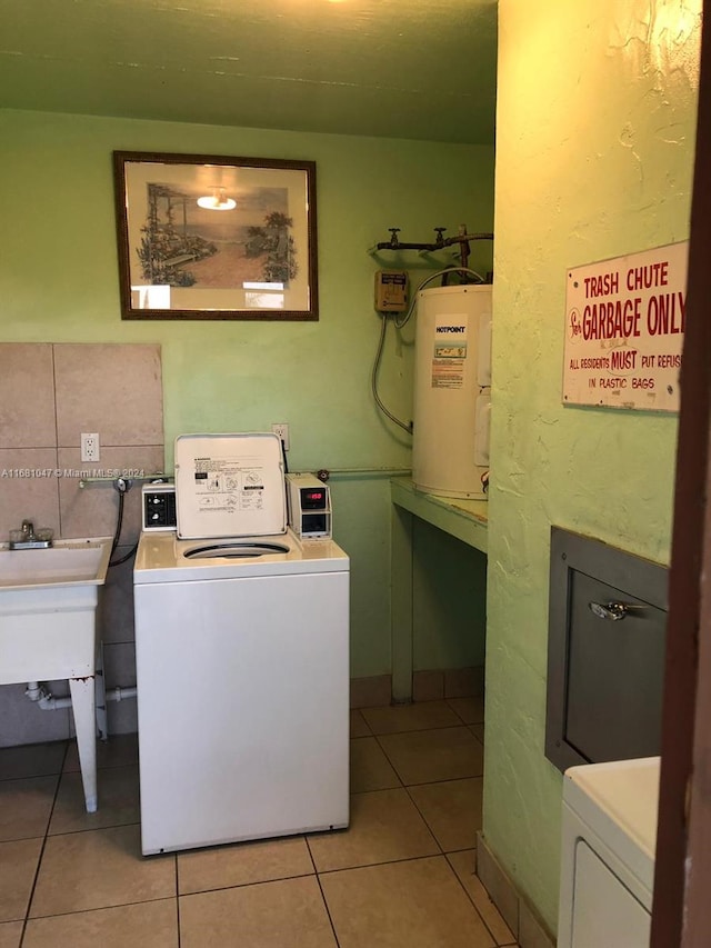 washroom with sink, light tile patterned flooring, separate washer and dryer, and water heater