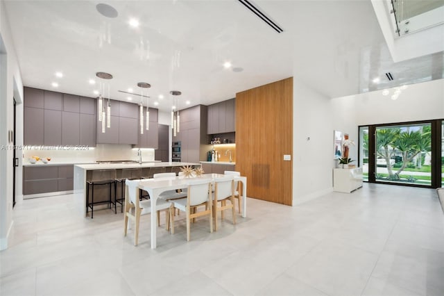 kitchen featuring a spacious island, hanging light fixtures, a kitchen breakfast bar, and light tile patterned floors