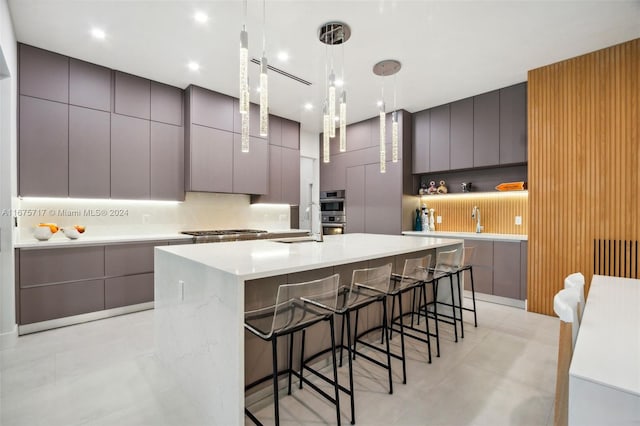 kitchen with a large island, tasteful backsplash, a breakfast bar, pendant lighting, and gray cabinets