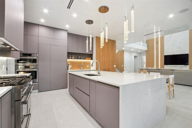 kitchen with gray cabinetry, appliances with stainless steel finishes, sink, a spacious island, and hanging light fixtures