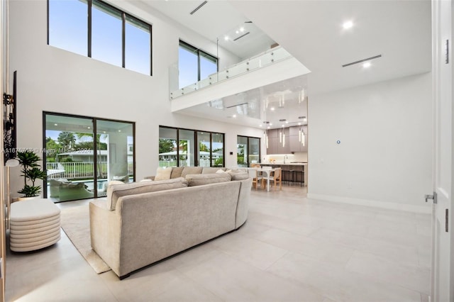 living room with light tile patterned floors and a high ceiling