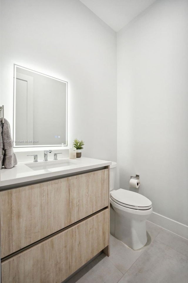 bathroom with vanity, toilet, and tile patterned flooring