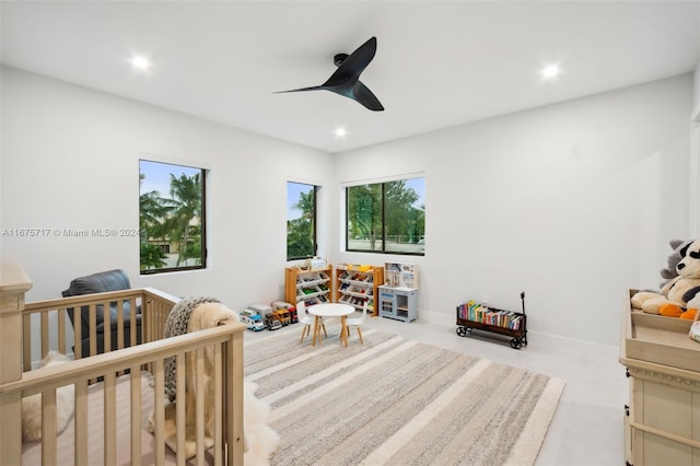 bedroom featuring ceiling fan and a nursery area