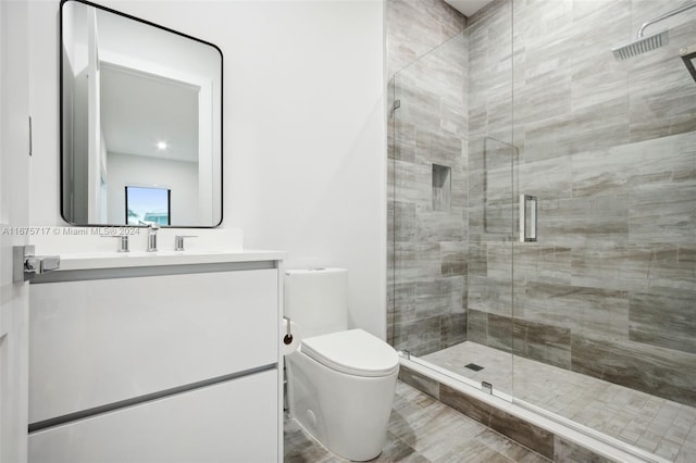 bathroom with vanity, toilet, and a shower with shower door