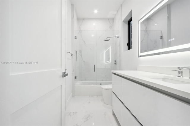 full bathroom featuring toilet, vanity, and shower / bath combination with glass door