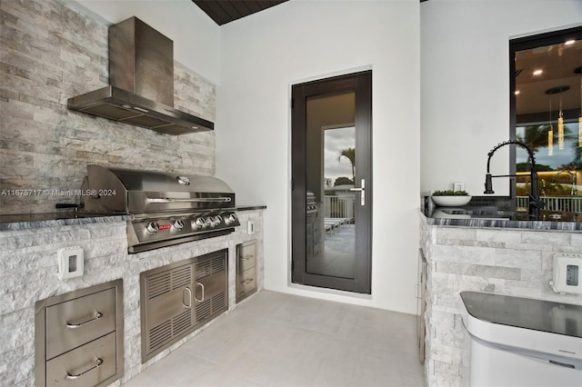 kitchen featuring sink, wall chimney exhaust hood, and light tile patterned flooring