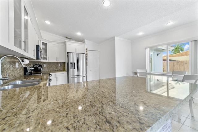 kitchen with white cabinetry, appliances with stainless steel finishes, sink, and a textured ceiling