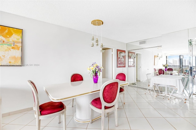 dining space featuring a textured ceiling and light tile patterned floors