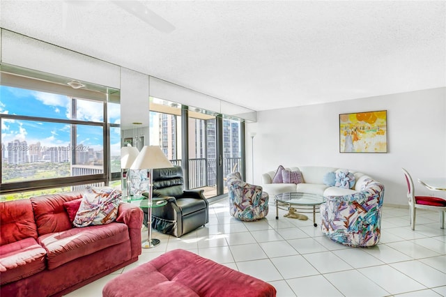 living room featuring a textured ceiling, light tile patterned floors, and floor to ceiling windows