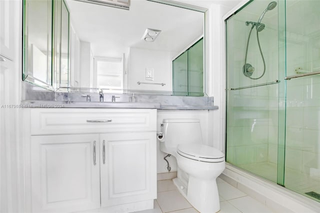 bathroom with vanity, toilet, walk in shower, and tile patterned flooring