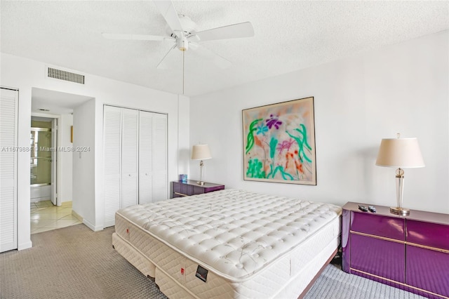 carpeted bedroom featuring a closet, a textured ceiling, and ceiling fan