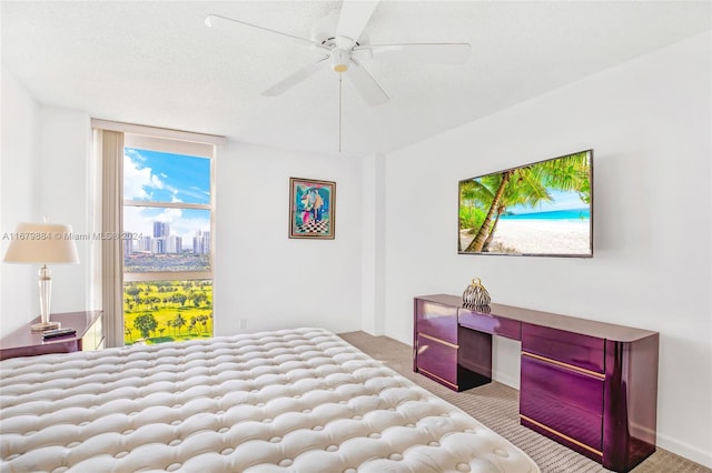 bedroom with built in desk, light carpet, a textured ceiling, and ceiling fan