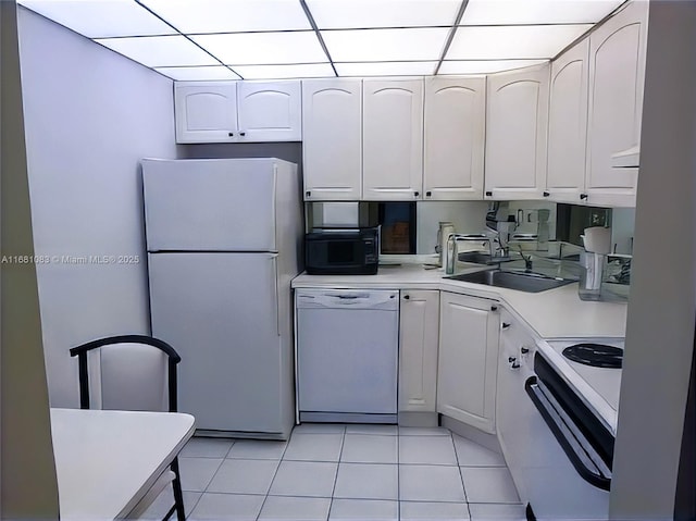 500 Three Islands Blvd Unit 116, Hallandale Beach, FL 33009 - kitchen featuring a sink, white appliances, light tile patterned floors, light countertops, and white cabinetry