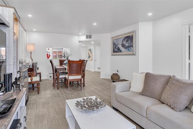 living area featuring baseboards, visible vents, and recessed lighting