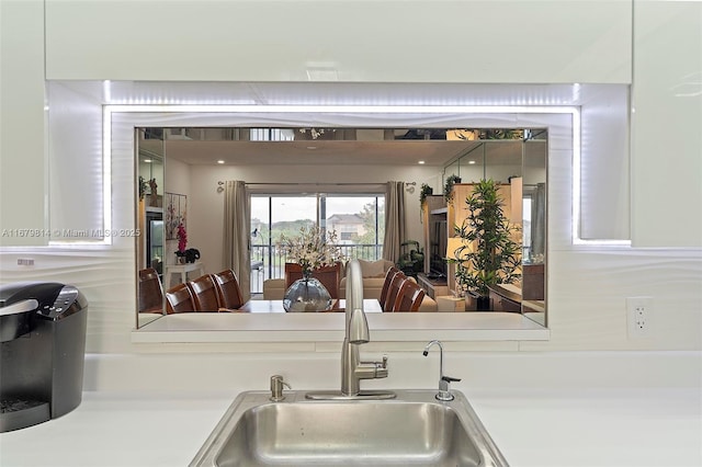 kitchen with light countertops, a sink, and white cabinetry