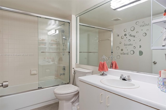 bathroom with visible vents, shower / bath combination with glass door, vanity, and toilet