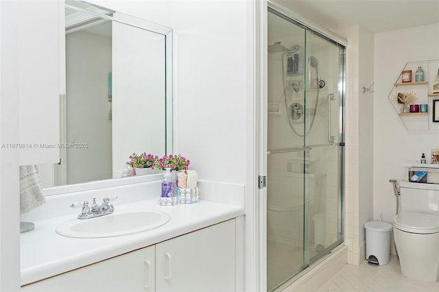 full bath featuring a stall shower, vanity, toilet, and tile patterned floors