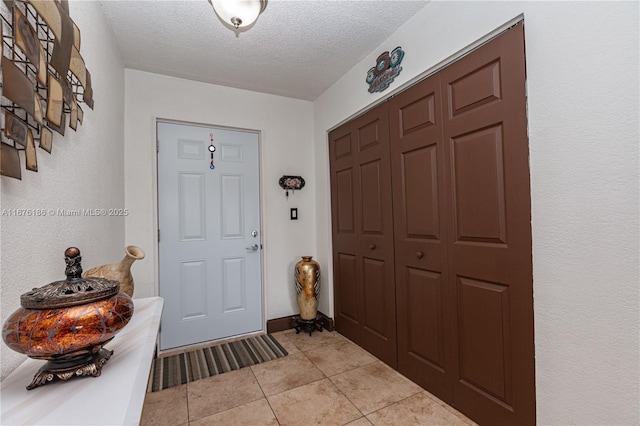 tiled entryway with a textured ceiling