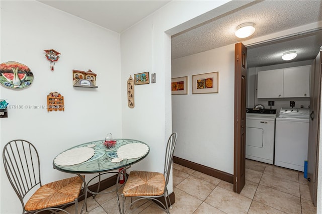 dining space with light tile patterned floors, washer and dryer, and a textured ceiling