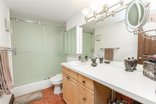 bathroom featuring vanity, toilet, and a shower with door