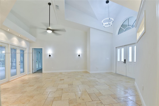 interior space featuring french doors, ceiling fan with notable chandelier, and high vaulted ceiling