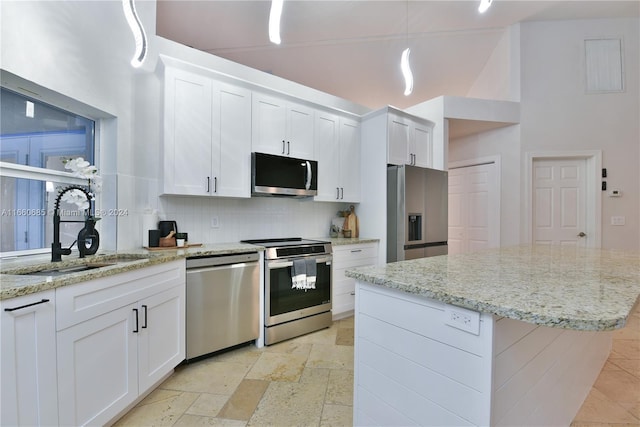 kitchen with high vaulted ceiling, appliances with stainless steel finishes, sink, and white cabinets