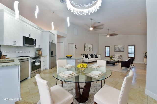 dining area with high vaulted ceiling and ceiling fan