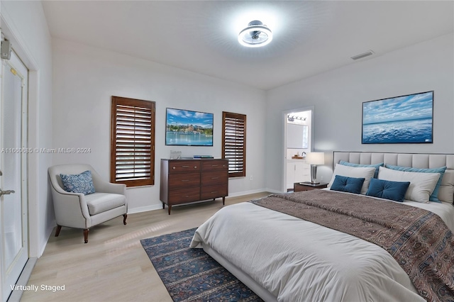 bedroom featuring light hardwood / wood-style flooring and multiple windows