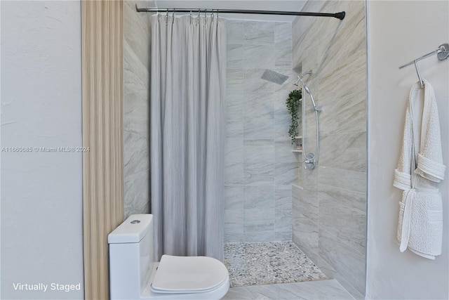 bathroom featuring toilet and a shower with curtain