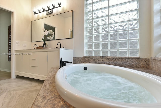 bathroom with vanity and a washtub