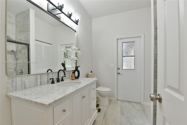 bathroom featuring a shower with door, vanity, and toilet