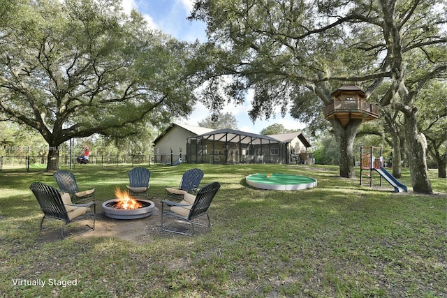 view of yard with an outdoor fire pit and a playground