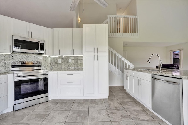 kitchen featuring light stone countertops, white cabinetry, and stainless steel appliances