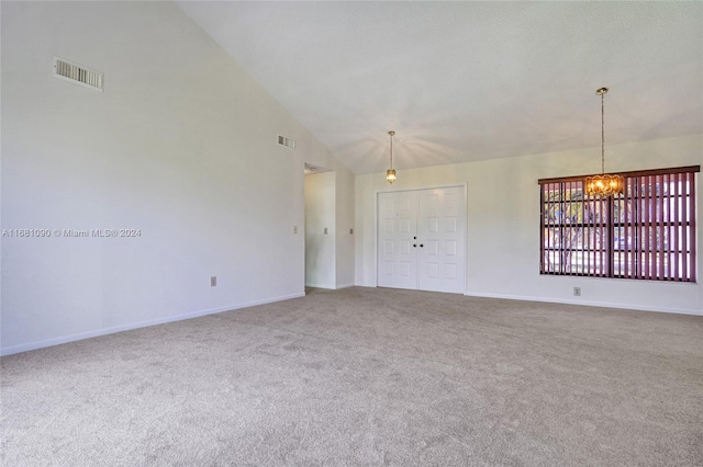 spare room featuring high vaulted ceiling, carpet floors, and an inviting chandelier