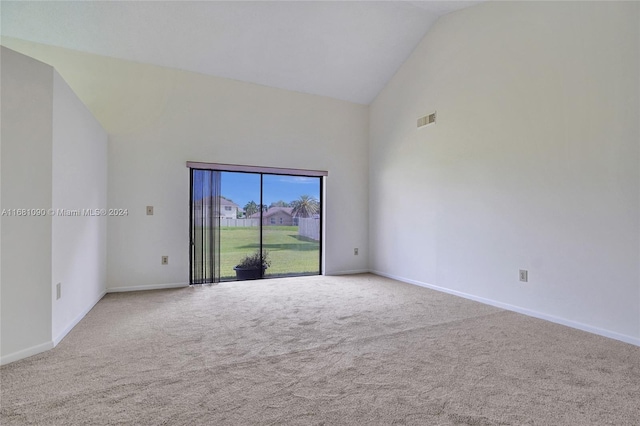 carpeted empty room featuring high vaulted ceiling