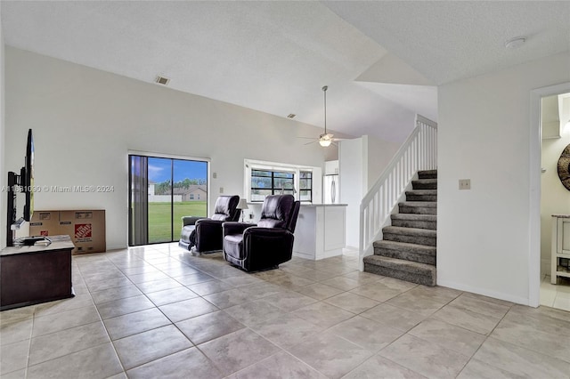 tiled living room with a textured ceiling, high vaulted ceiling, and ceiling fan