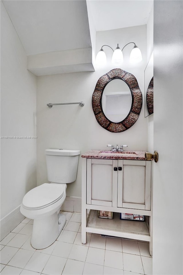 bathroom featuring toilet, vanity, and tile patterned flooring