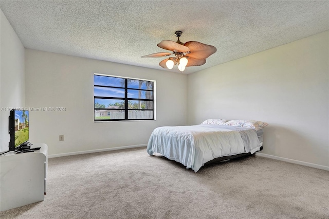 bedroom with a textured ceiling, carpet floors, and ceiling fan