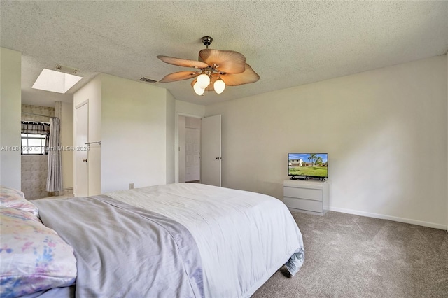 bedroom with ceiling fan, a textured ceiling, a skylight, and light colored carpet