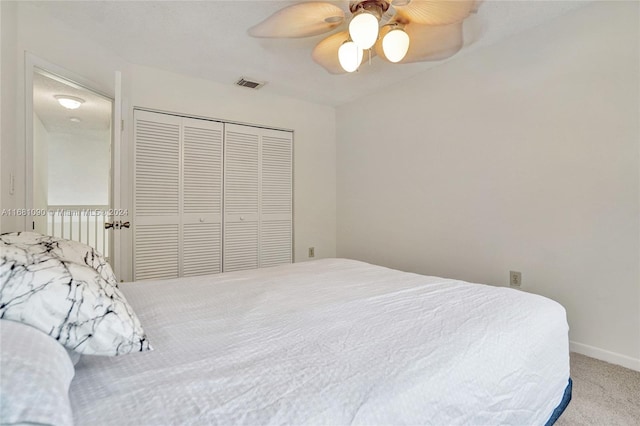 bedroom featuring a closet, light colored carpet, and ceiling fan