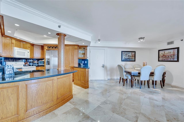 kitchen with crown molding, ornate columns, white appliances, and tasteful backsplash