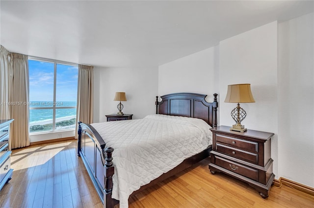 bedroom with a water view and light wood-type flooring