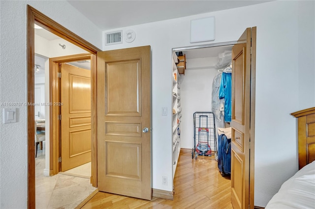 bedroom with light hardwood / wood-style floors and a closet